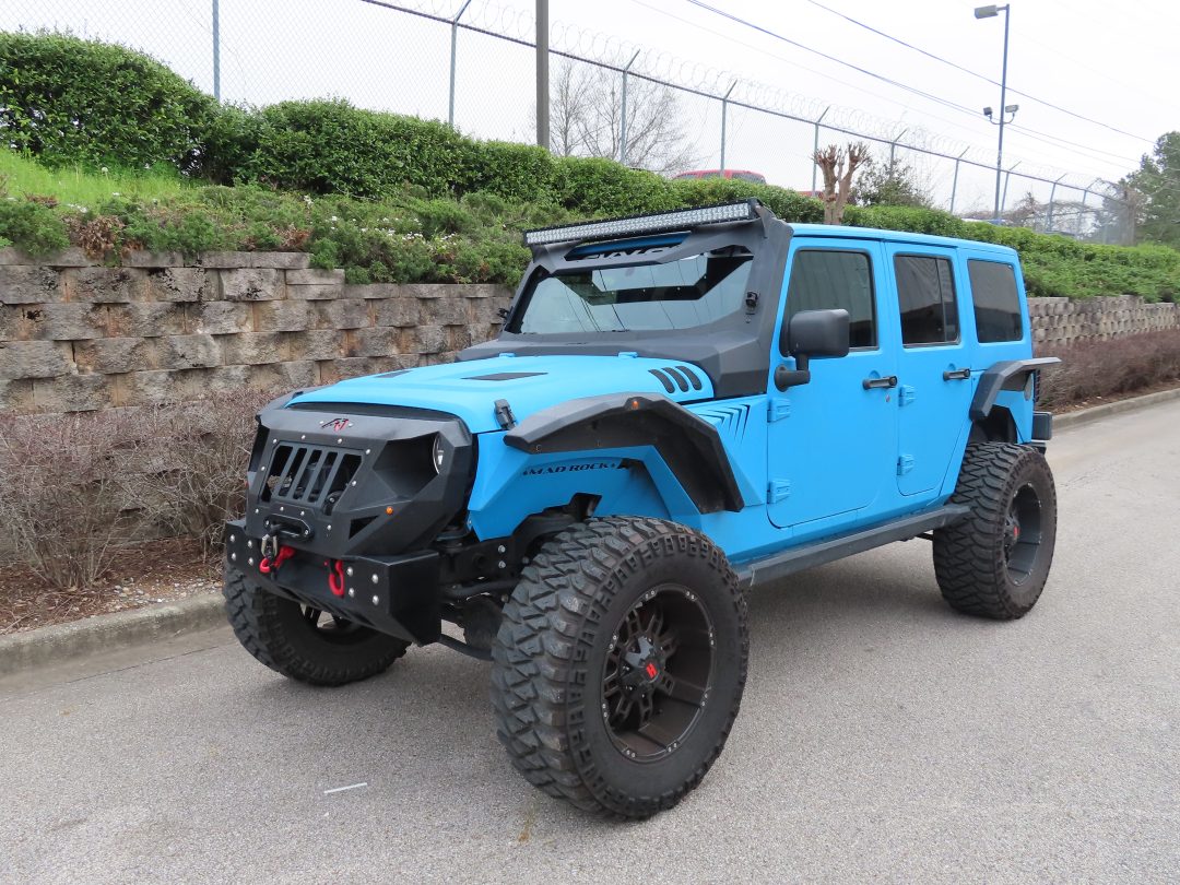 Blue jeep with tinted windows, front view